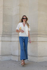a lady in a white lace top and a pair of jeans